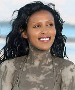 girl with dark curly hair in mud