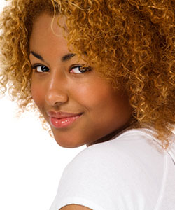 model with naturally tight curly hair in ginger color